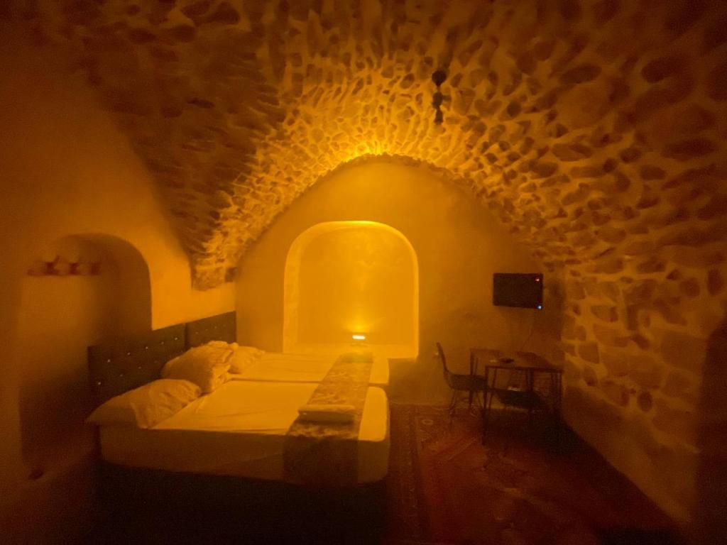 马尔丁Gılgamesh butik otel的一间卧室设有一张床和石墙
