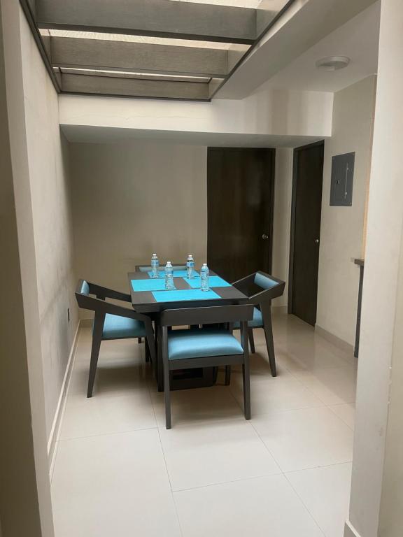 马萨特兰圣路易斯套房公寓的一间带桌子和蓝色椅子的用餐室