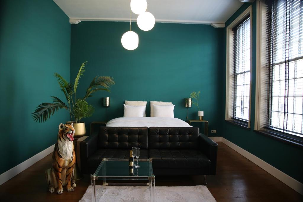 奈梅亨Philipse Suite的一间卧室配有一张床和一张黑色皮沙发