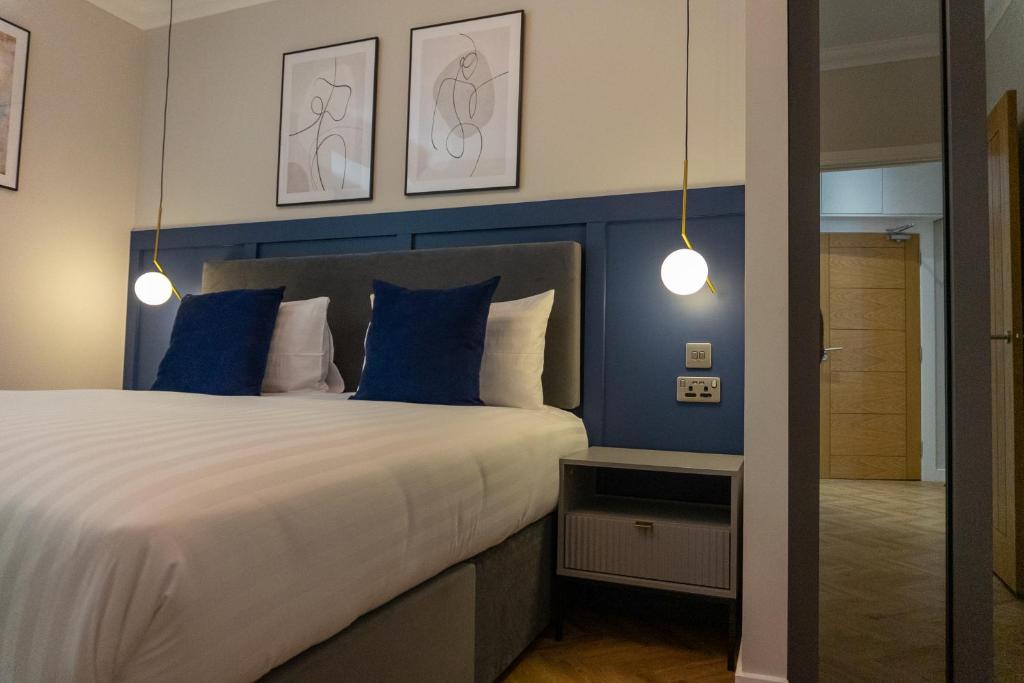 奥本Oban Apartments的一间卧室配有一张带蓝色墙壁的大床