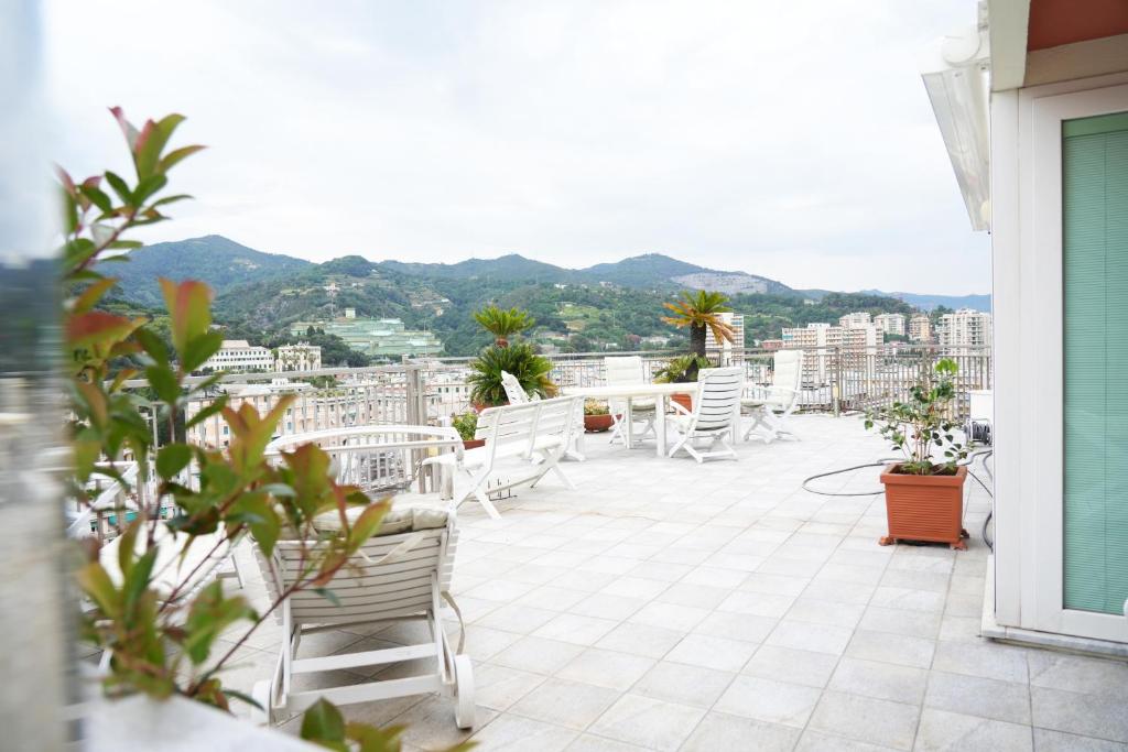 热那亚Casa Amina的阳台配有白色椅子,享有城市美景。