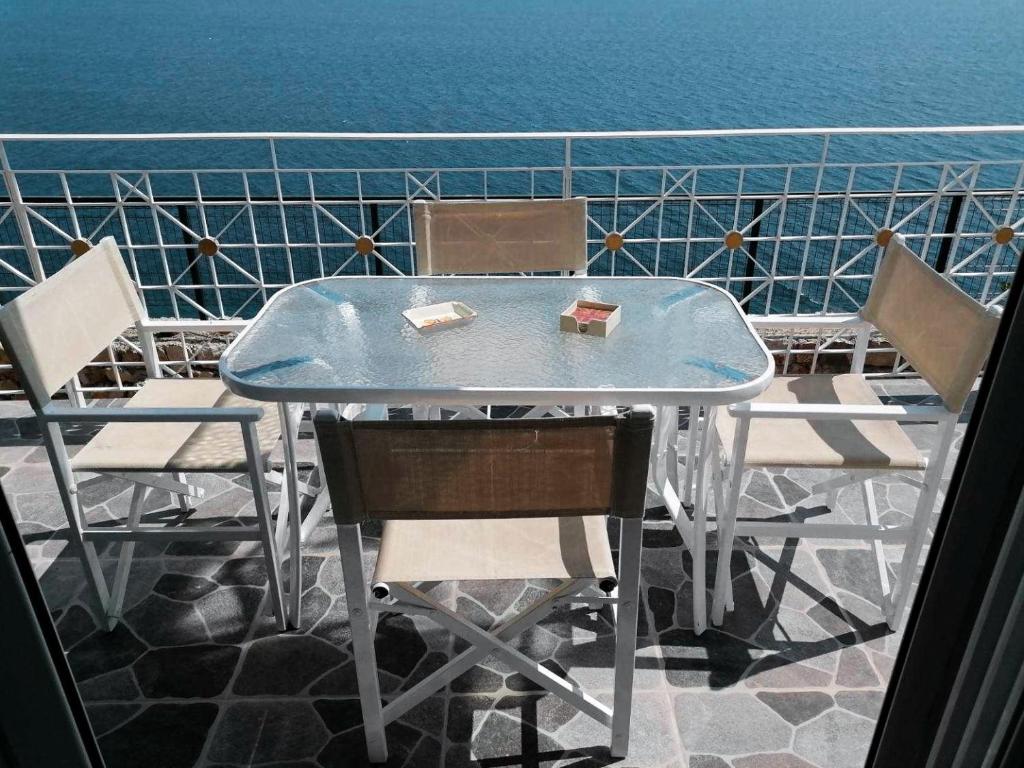 萨兰达Vila SHAKAJ的一张桌子和椅子,背景是大海