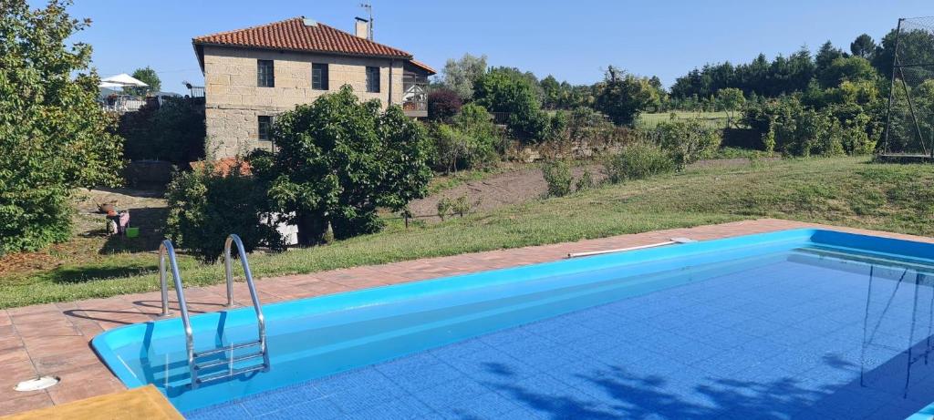 诺盖拉德拉姆Caserio de Fontes的一座大蓝色游泳池,位于房子前