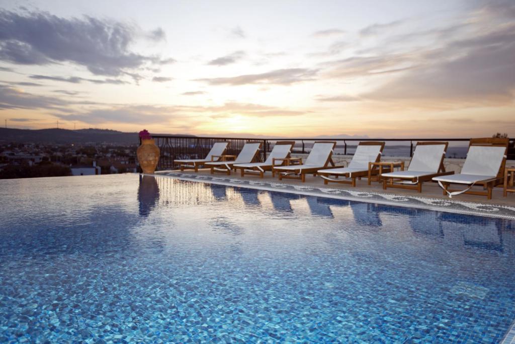 阿拉恰特阿拉恰特彩色别墅酒店的酒店游泳池设有椅子,享有日落美景
