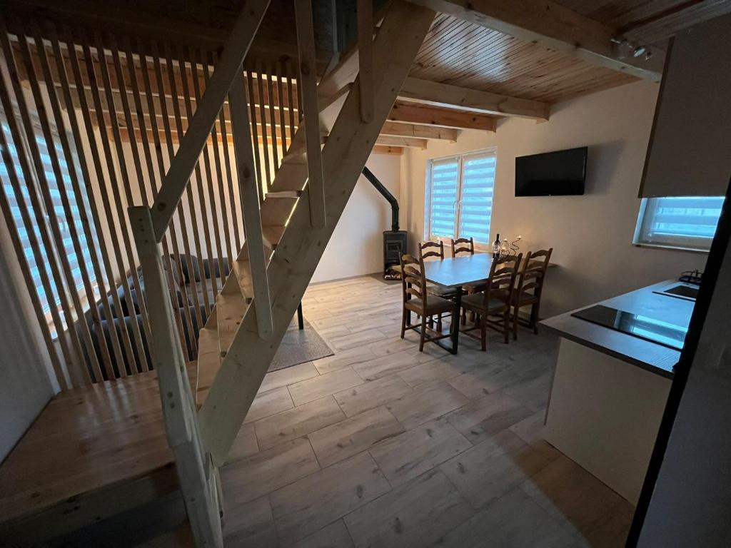 WodnicaDomki całoroczne STAWIK的房屋内的厨房和用餐室,配有木楼梯