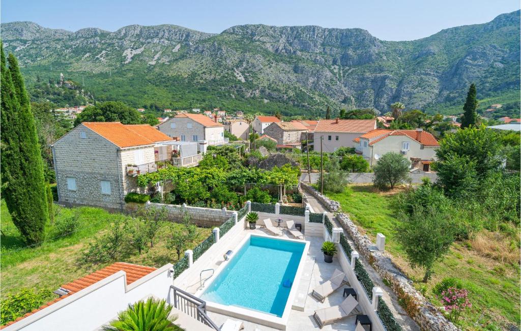 杜布罗夫尼克Awesome Apartment In Dubrovnik With Jacuzzi的一座带游泳池和山脉的别墅