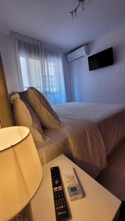 圣卡洛斯拉腊皮塔Apartamento Sol y Mar的一间卧室配有一张带遥控器的桌子。