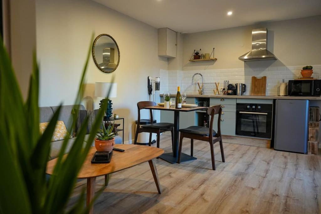 索姆河畔的圣瓦列里Appartement Saint-Valery的厨房以及带桌椅的起居室。