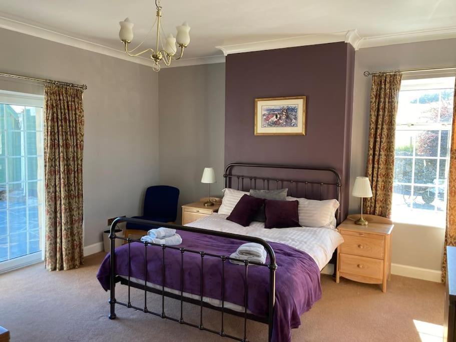 DalryPolharrow的一间卧室配有一张带紫色床罩的床
