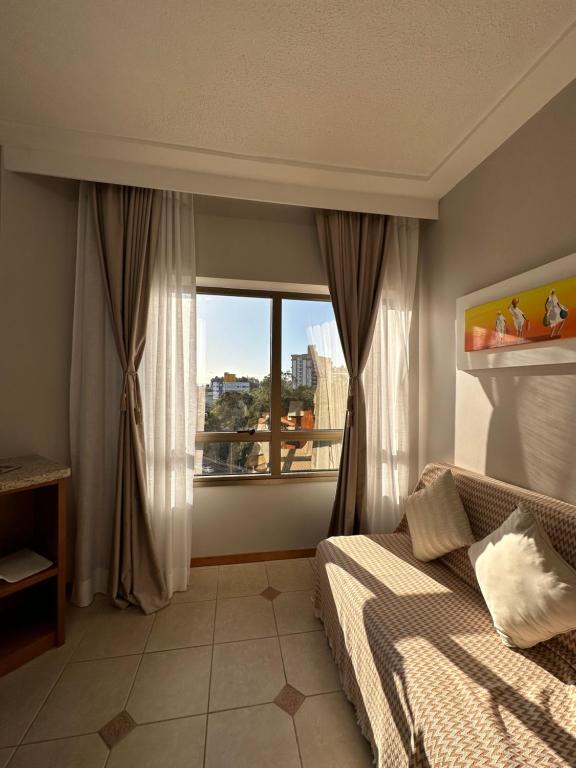 弗洛里亚诺波利斯Apartamento executivo的一间卧室设有一张床和一个大窗户