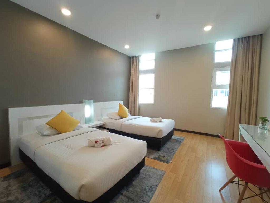 关丹Lovita Hotel Kuantan的酒店客房配有两张床和一张书桌