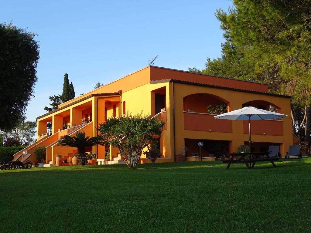奥特朗托Sole del Mediterraneo的院子里有雨伞的黄色建筑