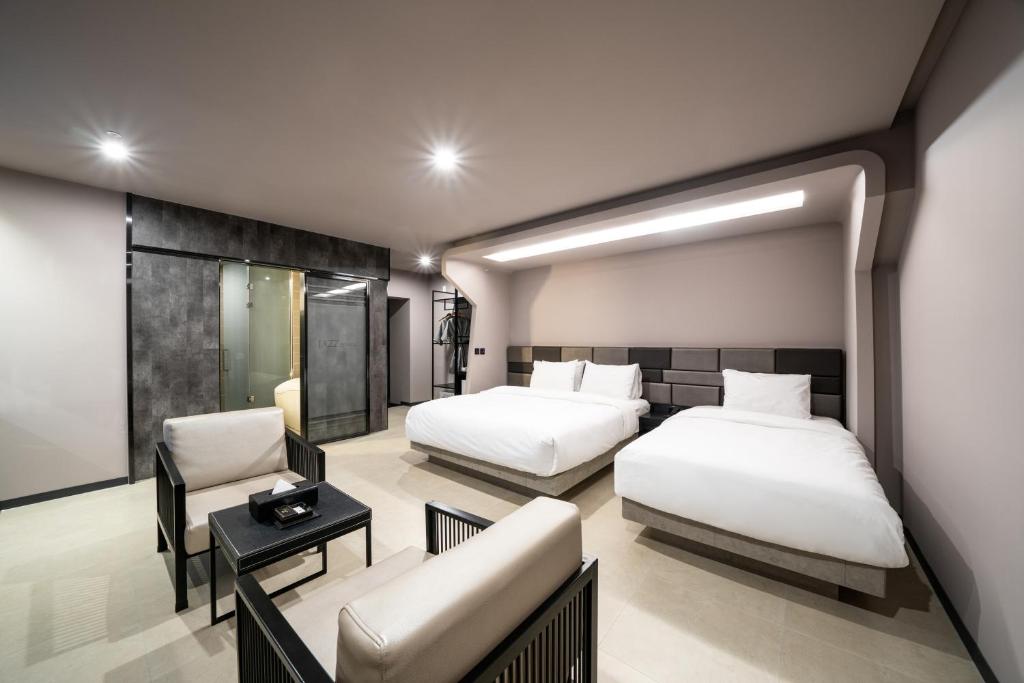 全州市Jeonju Jazz Around Hotel的酒店客房,设有两张床和一张沙发