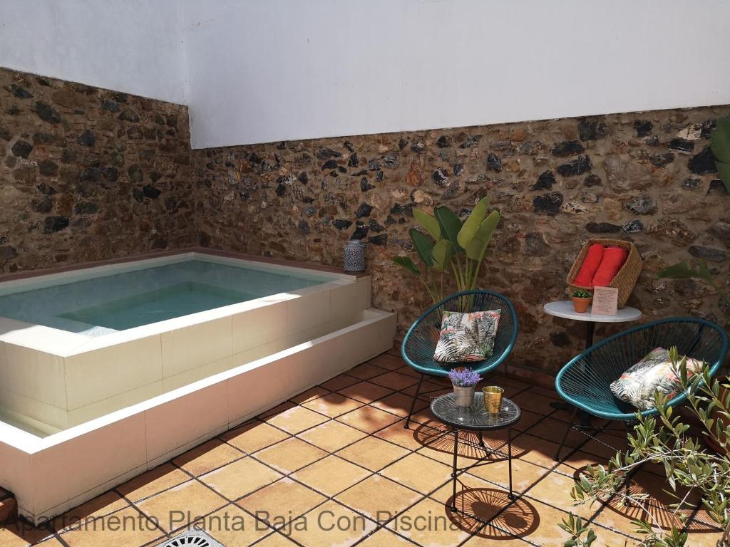 梅里达Apartamentos Durán Pizarro 1930的带浴缸和两把椅子的房间