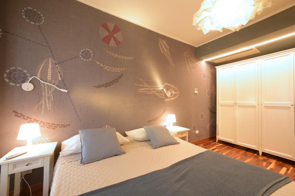 阿拉西奥布里斯托尔酒店的一间卧室配有一张床,墙上挂着绘画。