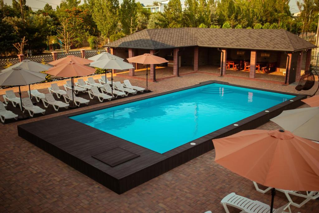 科布列韦REEF Hotel的享有带椅子和遮阳伞的游泳池的上方景色