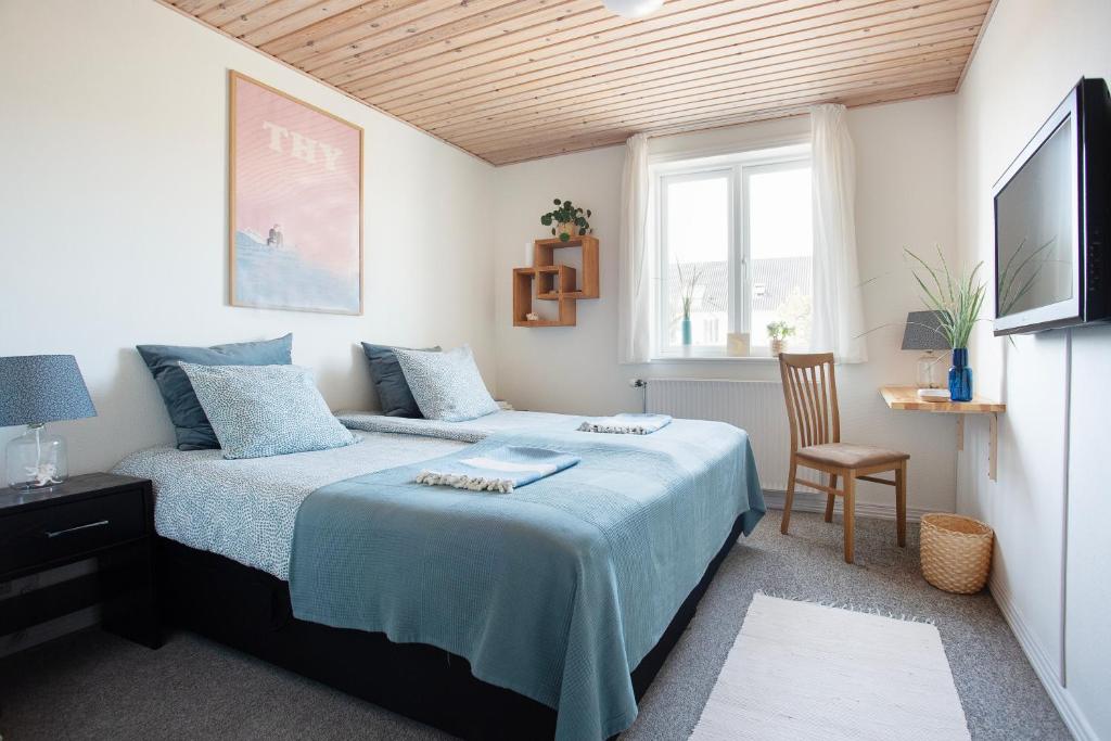 StenbjergStone Mountain BnB的卧室配有床、椅子和窗户。