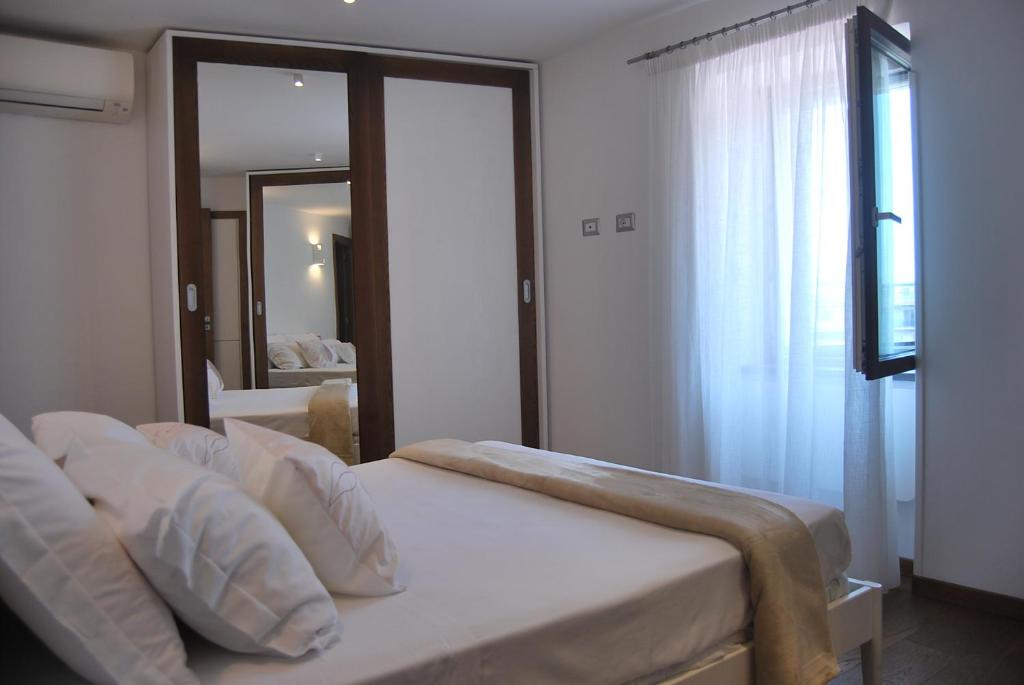 马奥莱LA CASA DI SASA'的卧室配有带白色枕头的床和窗户。