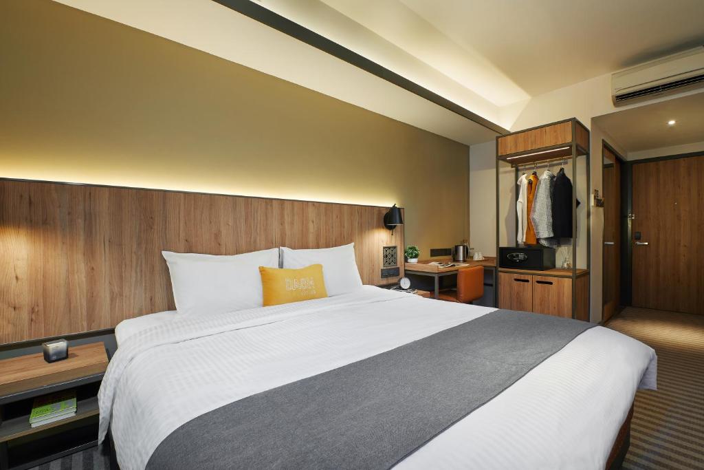 新加坡Dash Living Rochor的酒店客房设有一张大床和一张书桌。