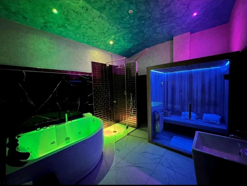 巴罗尼西Setteabbracci Suite & Apartments的一间带绿色浴缸的浴室和大窗户