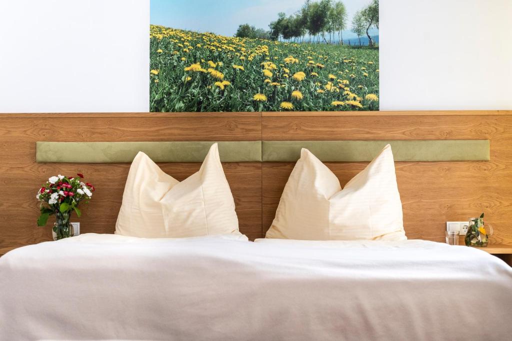 Mönichwald加斯特伍德夏夫特霍尔德酒店的一张带白色枕头和鲜花的床