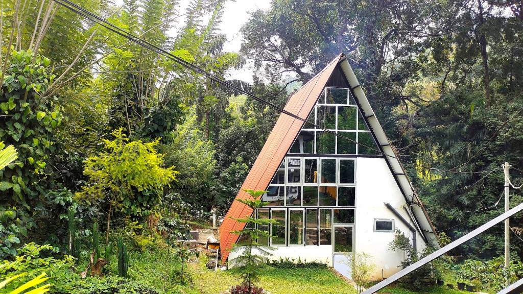 RattotaRiverston Nature Villa的花园中带三角形屋顶的小房子
