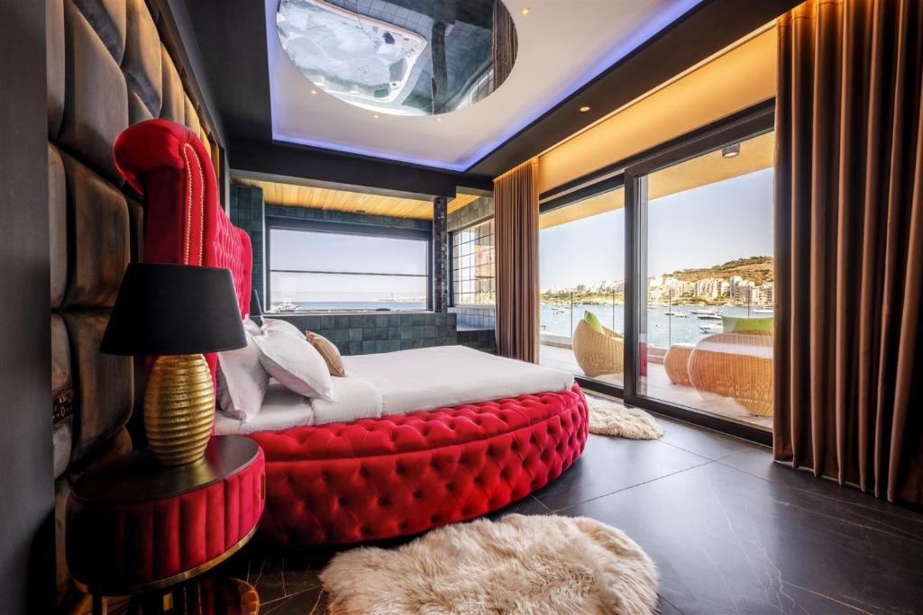 圣保罗湾城Ushuaia Playa Xemxija Boutique Hotel的一间卧室配有一张红色的搁脚凳的床
