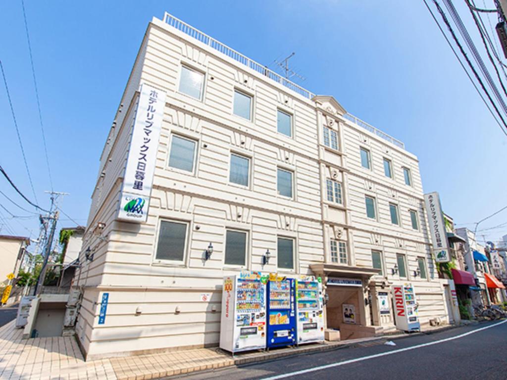 东京HOTEL LiVEMAX BUDGET Nippori的街道拐角处的白色大建筑