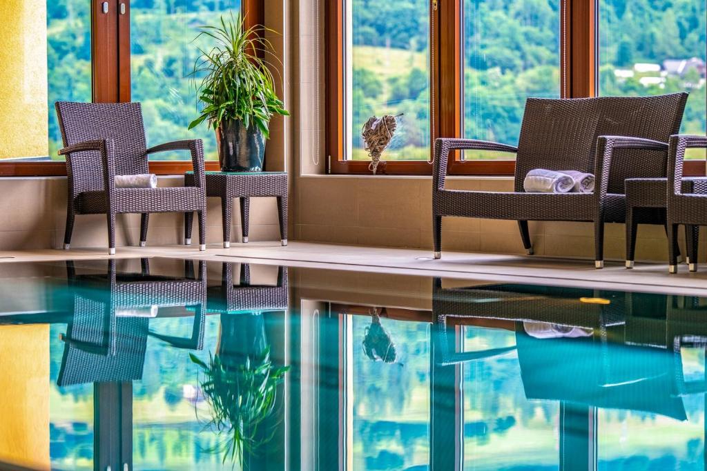 穆劳附近圣格奥尔根克里斯赫伯格休闲度假酒店的配有椅子和桌子的房间,水中反射