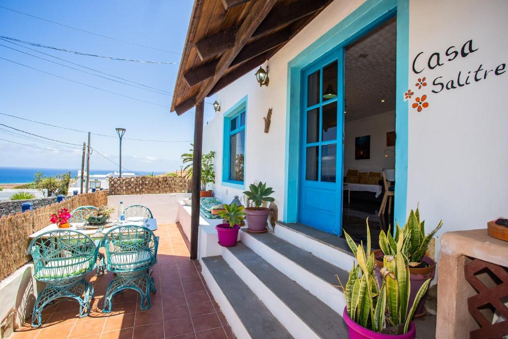 TabayescoEco Casa Salitre,Montaña, Campo y Playa的一个带蓝色门、椅子和植物的庭院