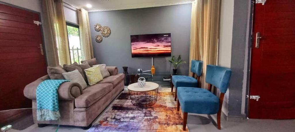 KitweZachi Apartments的客厅配有沙发和蓝色椅子
