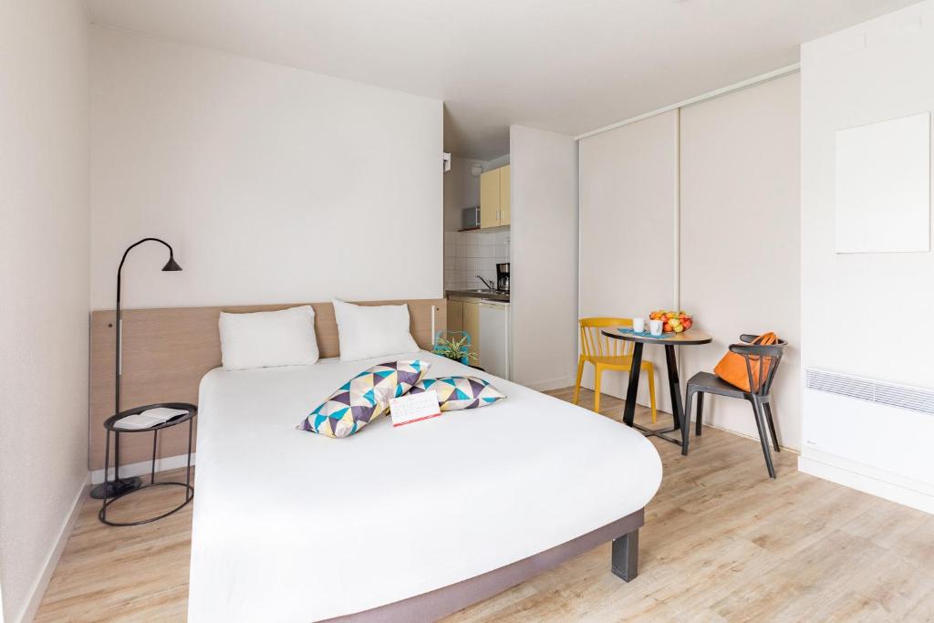 雷恩Appart'City Classic Rennes Ouest的卧室配有白色的床和桌子