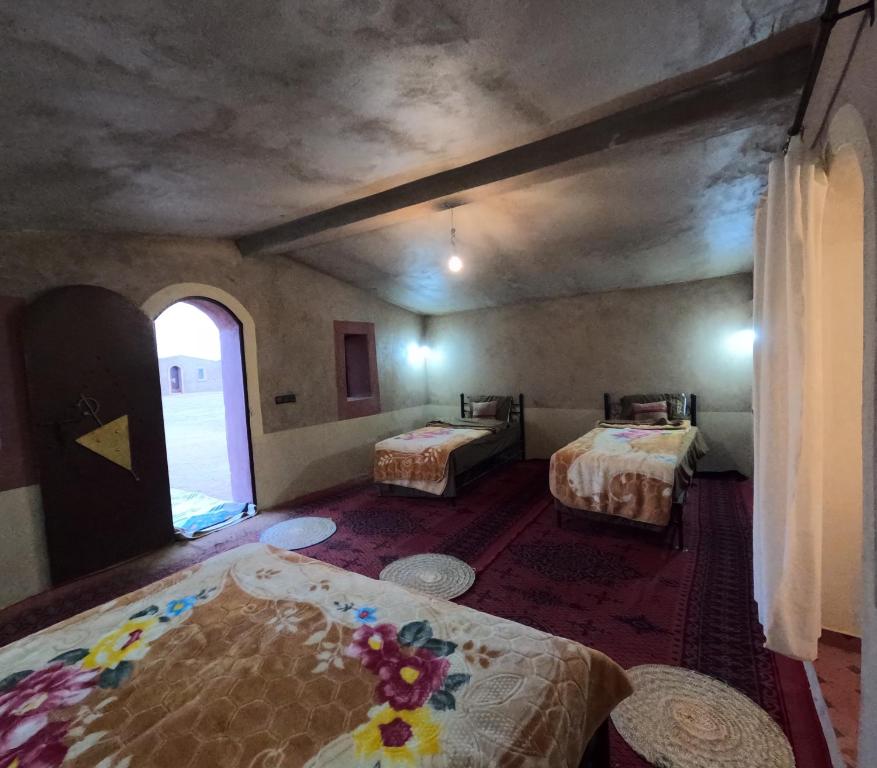 MhamidSahara Luxury Camp M'hamid的客房设有两张床和窗户。