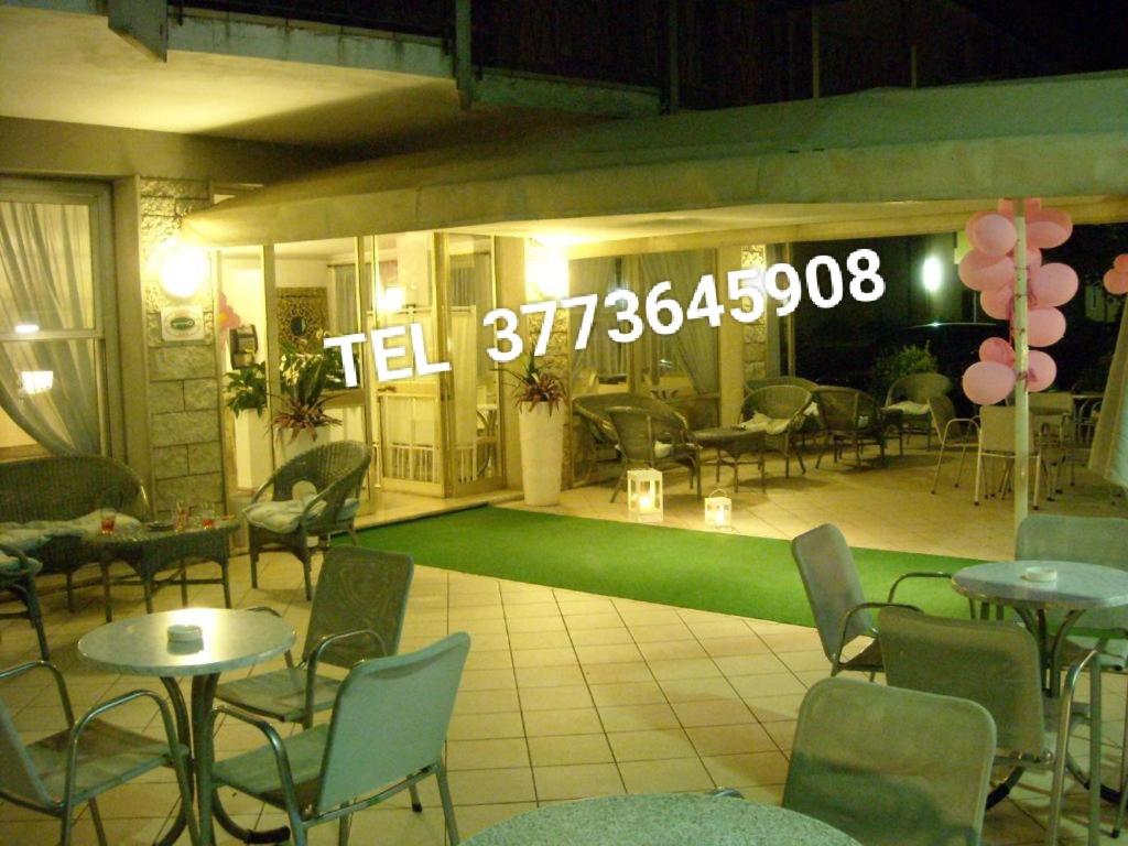 米兰马瑞提那海地酒店 的一间设有桌椅的餐厅,位于绿色的地板上