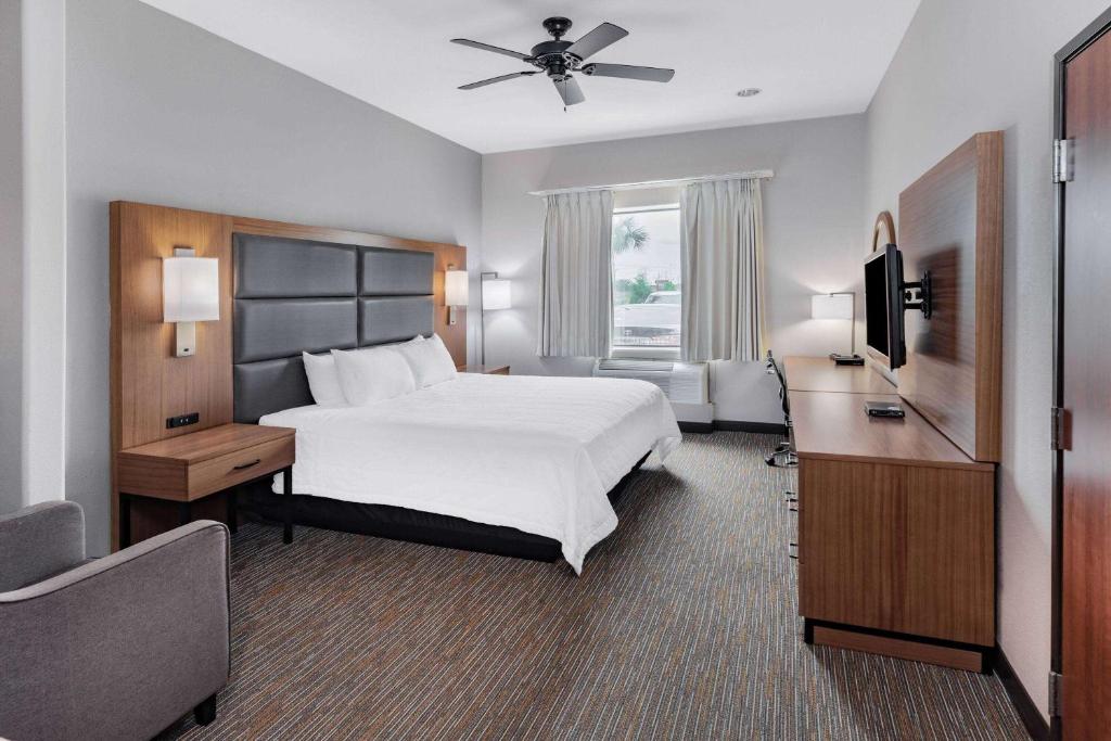 休斯顿Wingate by Wyndham Houston Bush Intercontinental Airport的配有一张床和一台平面电视的酒店客房