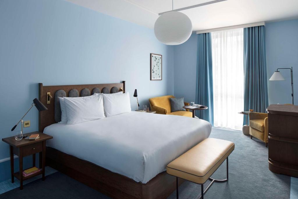 剑桥Hyatt Centric Cambridge的酒店客房带一张大床和一把椅子