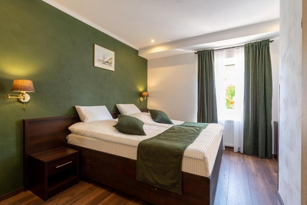 杜塞尔多夫Jupa's Hotel的一间卧室设有一张带绿色墙壁的大床