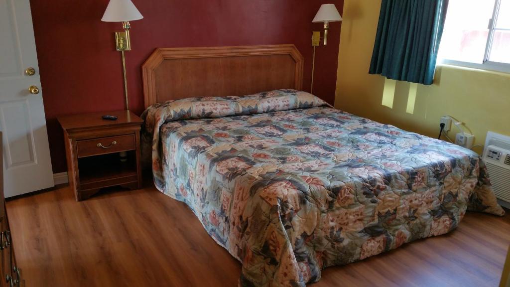 默塞德斯拉博尔汽车旅馆的一间卧室配有床、床头柜和一张四柱床