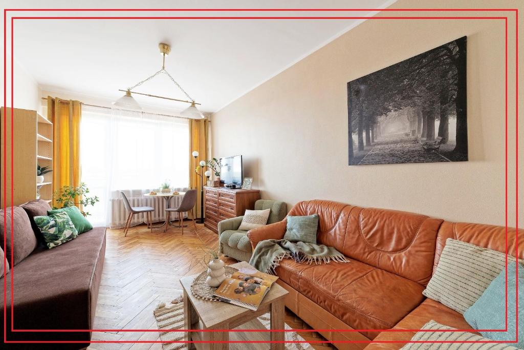 格但斯克Apartament 2 pokoje blisko morza 1000 metrów w Gdańsku的客厅配有棕色皮沙发和桌子