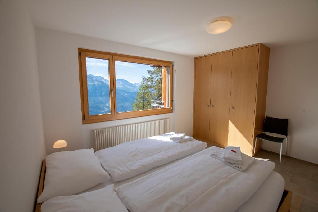 利德阿尔卑斯贝拉维斯塔公寓式酒店的一间卧室设有两张白色的床和窗户