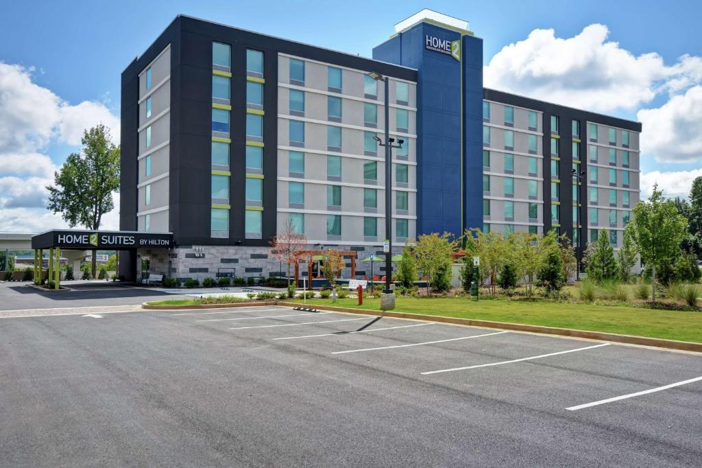 玛丽埃塔市Home2 Suites By Hilton Atlanta Marietta, Ga的一座大型建筑,前面设有停车场