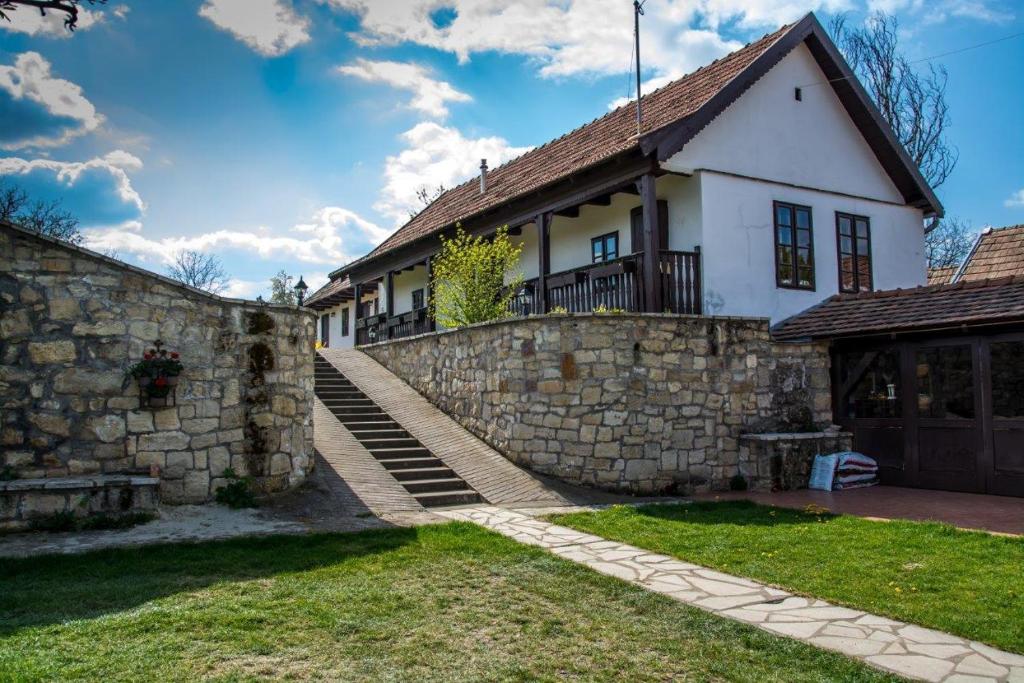 VanyarcKemencés Vendégház的一座石墙和围栏的房子