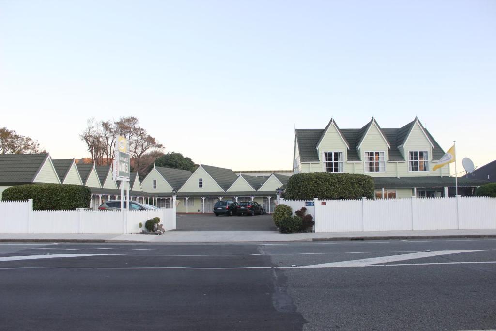 下哈特ASURE Green Gables Motel的一排房屋,有白色的围栏和街道
