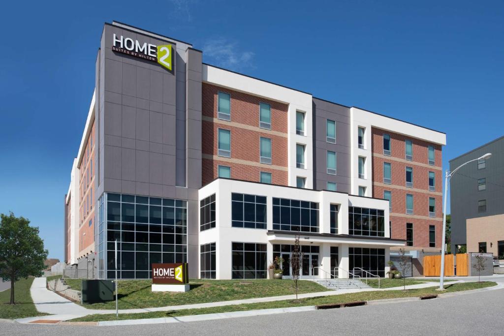 奥马哈Home2 Suites By Hilton Omaha Un Medical Ctr Area的一座酒店大楼,前面有标志