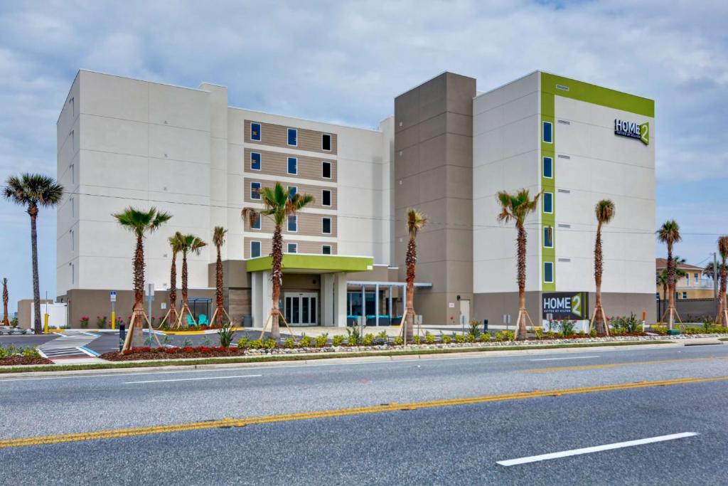 奥蒙德海滩Home2 Suites Ormond Beach Oceanfront, FL的棕榈树酒店前的一条空路