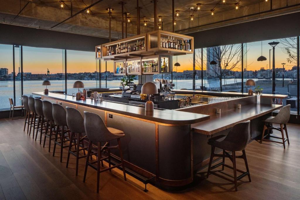 巴尔的摩Canopy By Hilton Baltimore Harbor Point - Newly Built的餐厅内的酒吧享有水景