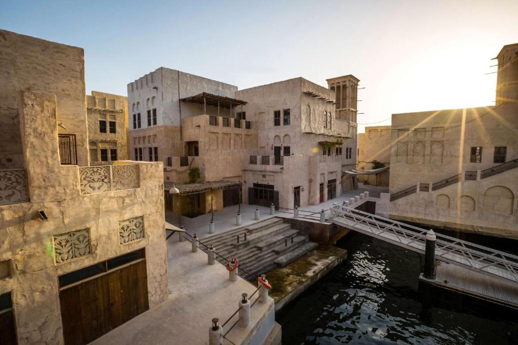 迪拜Al Seef Heritage Hotel Dubai, Curio Collection by Hilton的运河旁的一组建筑物