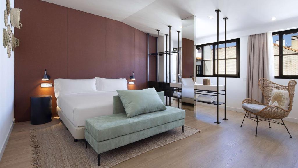 马德里Atocha Hotel Madrid, Tapestry Collection by Hilton的一间卧室配有一张床、一把椅子和一张书桌