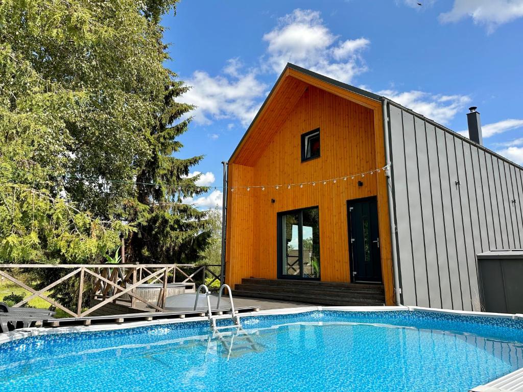 VecumniekiSemo guest house with amazing sauna and pool的一座房子前面设有游泳池