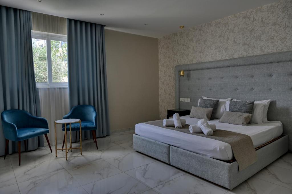 艾因西莱姆Ta Benna Villa的一间卧室配有一张大床和一张蓝色椅子